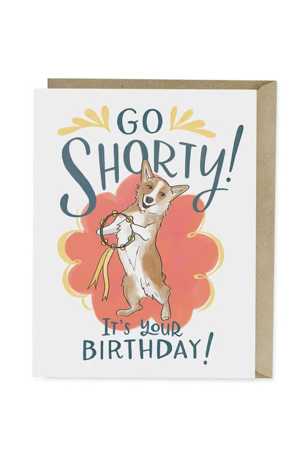 Greeting card that says Go Shorty! It's your Birthday! The card features a corgi holding a tambourine in front of a red flower shaped background. 