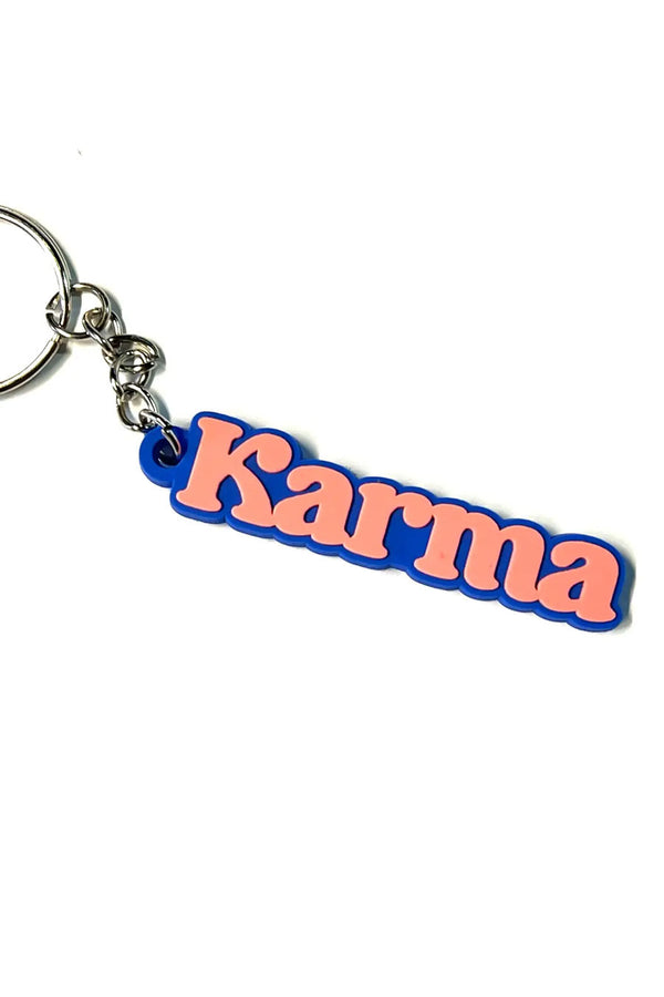 Blue rubber keychain that says Karma in pink text.