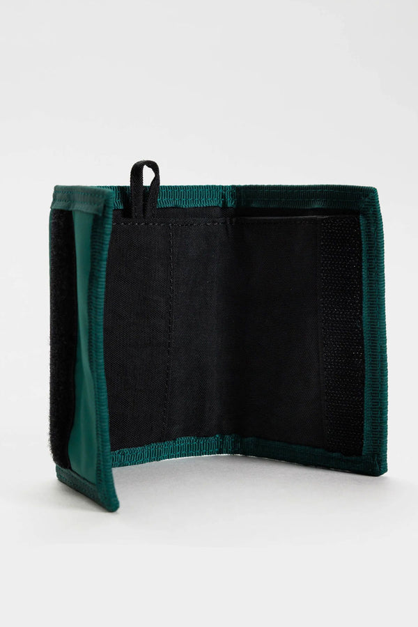 Interior photo of a velcro wallet. The wallet is a dark blue green color with a black nylon inside and features a key tag loop. White background.