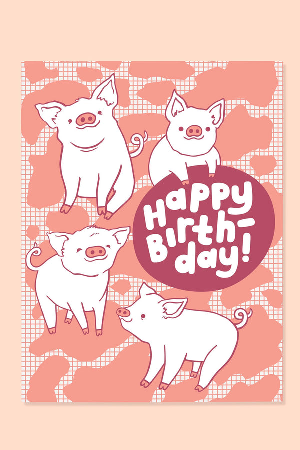 Greeting cards of four illustrated piglets against a pink grid background with pink shapes all over. The card says Happy Birthday. Peach background.