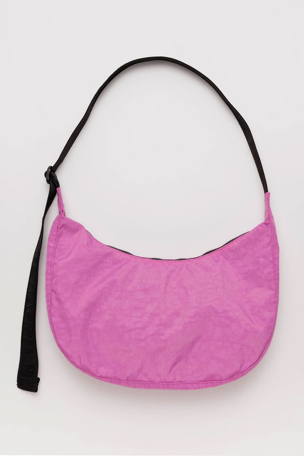 Pink nylon crescent shaped cross body bag with black straps.