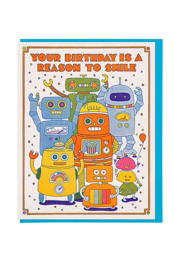Greeting card featuring several robots surrounded by confetti. Above the robots the card says Your Birthday is a Reason to Smile. Blue envelope. White background.