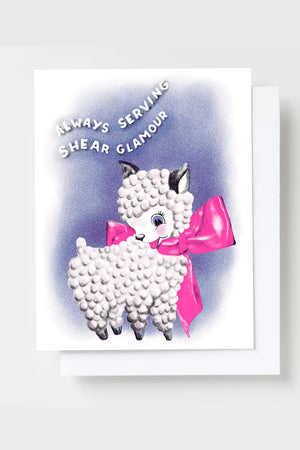 Greeting card featuring a sheep with a pink ribbon tied around its neck. The card says Always serving shear glamour.
