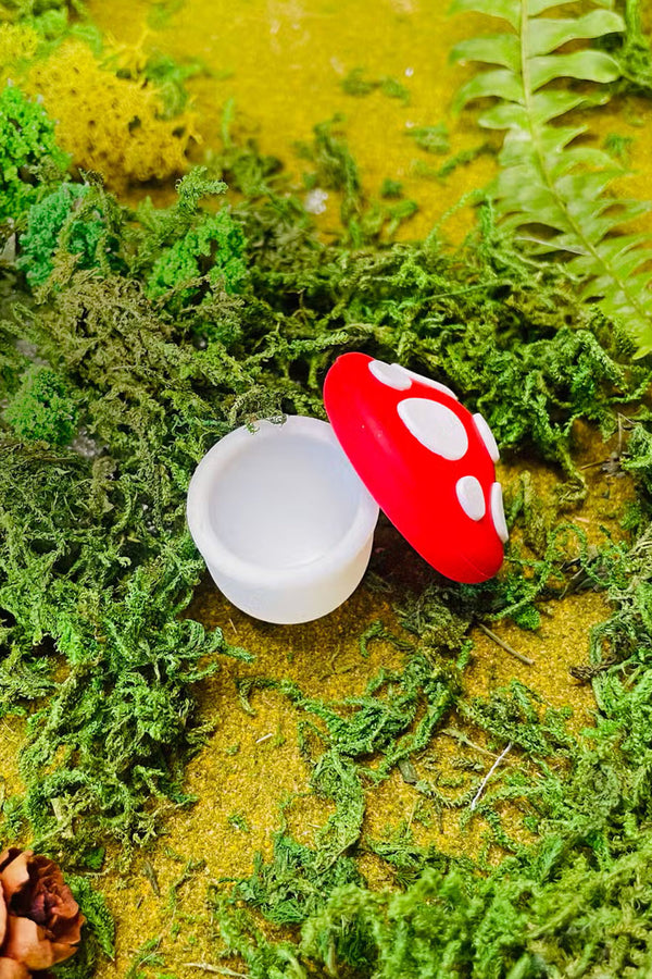 Small mushroom shaped silicone container with the top off of it.