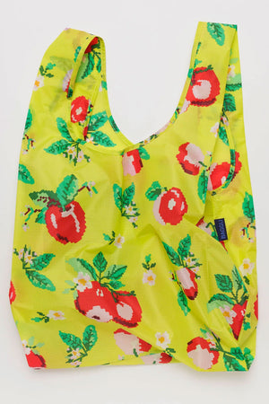 Large shopping bag in yellow with needle point style illustrations of apples with leaves and small white flowers. White background.