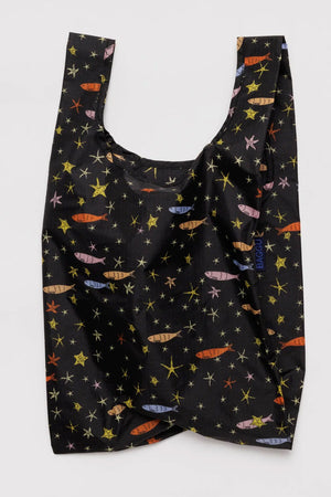 Black reusable tote covered in multicolor fish and stars. White background.