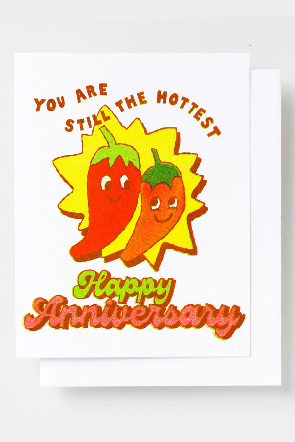 Greeting card featuring illustrated peppers side by side against a yellow background. The card says You Are Still The Hottest. Happy Anniversary. White background.