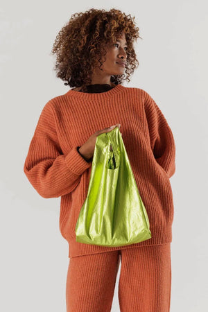 A person holding a Lime Green metallic reusable tote bag.