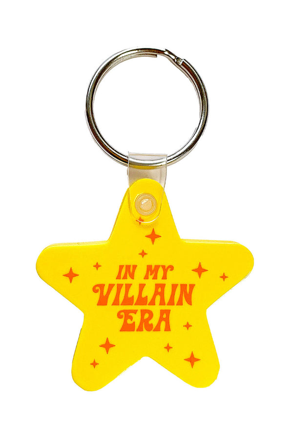 Flexible yellow star shaped keychain that says In My Villain Era in orange text.