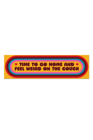 Yellow vinyl sticker with a red, burgundy, blue, and pink striped oval around text that says "Time to go home and feel weird on the couch".