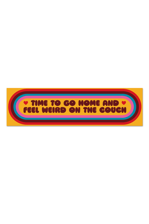 Yellow vinyl sticker with a red, burgundy, blue, and pink striped oval around text that says "Time to go home and feel weird on the couch".