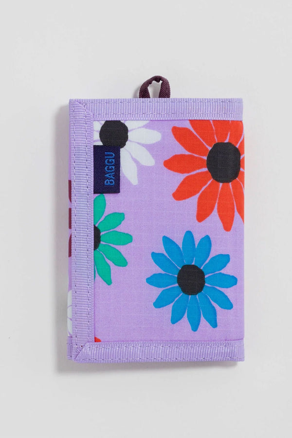 Light purple velcro wallet against a white background. The wallet features a small loop for a keychain and has red, blue, white, and red daisy flowers printed all over it. 