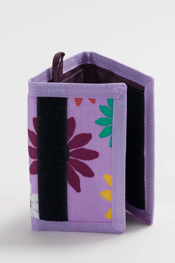 Light purple velcro wallet against a white background. The wallet features a small loop for a keychain and has red, blue, white, and red daisy flowers printed all over it. Dark purple wallet interior.
