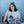 Load image into Gallery viewer, A woman with dark curly hair wearing the blue tie-dyed tee depicting the astrological symbols for &quot;Cancer.&quot; She is sitting at a table with vases full of water, wearing a flower crown.
