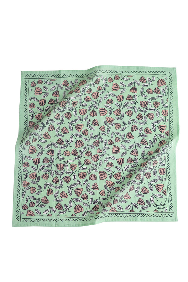 A mint green bandana with a pattern of whimsical pale pink flowers.