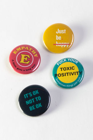 Four pinback buttons arranged on a white background.