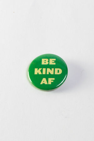 A green pinback button with block letters that read "Be Kind AF."