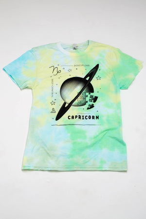 A green and yellow tie-dyed t-shirt depicting symbols representing the astrological sign "Capricorn."