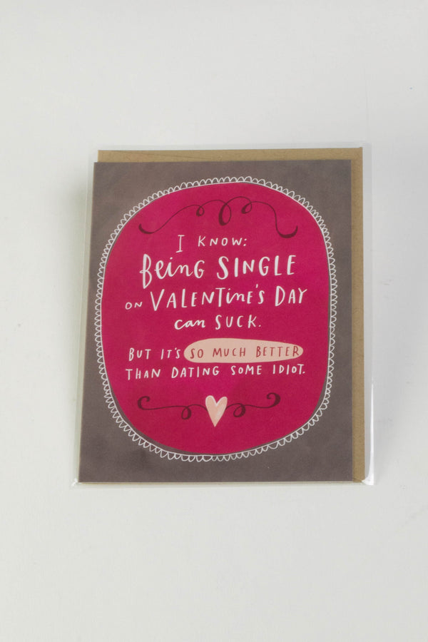 A Valentine's Day greeting card with a brown and pink background that reads "I know being single on Valentine's Day can suck. But it's so much better than dating some idiot."