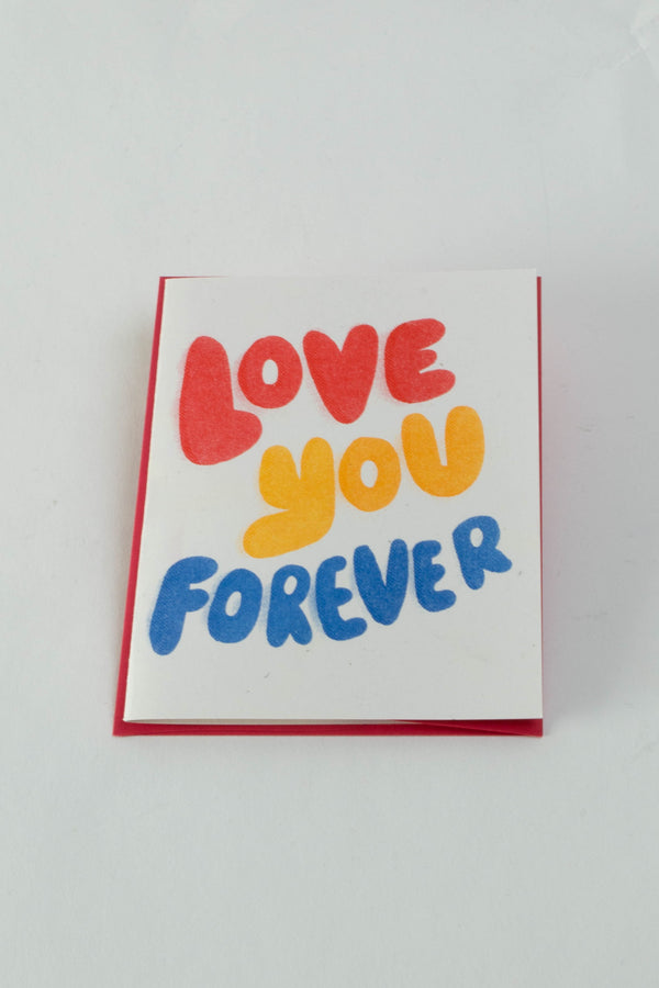 White card with red envelope on a white back ground. The card reads "Love You Forever" in red, yellow, and blue.