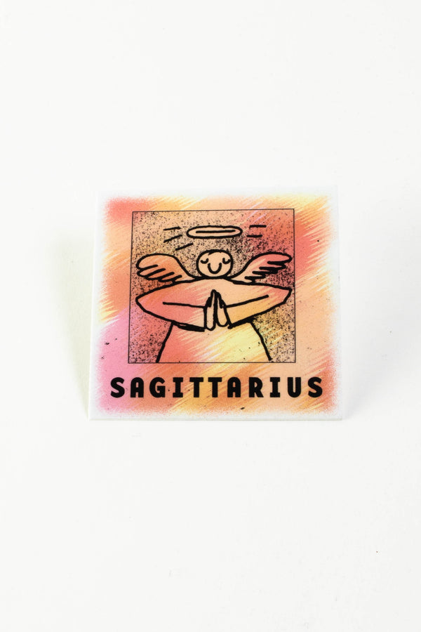 A square orange, pink, and yellow sticker depicting an illustrated angel. The black text at the bottom reads "Sagittarius."