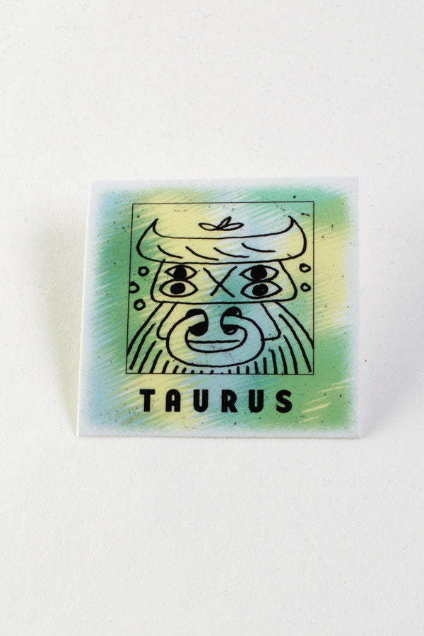 Square sticker of an illustrated Bull with horns and a nose ring. Underneath the bull the sticker says Taurus. The background of the sticker is a blend of yellow, green, and blue colors.