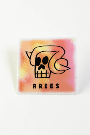 A square orange and yellow sticker with a depiction of the astrological symbol for Aries. 