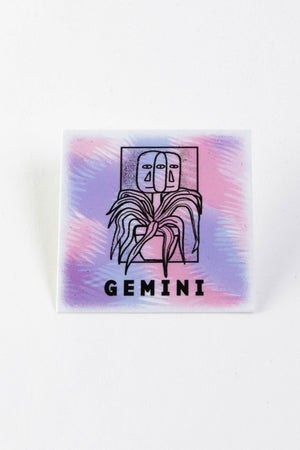 A square sticker with a purple and pink background and an illustration of two faces growing out of a potted plant. The text reads "Gemini."