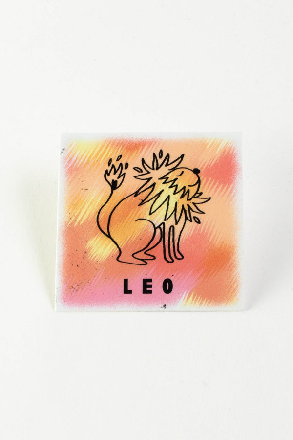 A square sticker with an orange and yellow background and an illustration of a whimsical lion. The black text at the bottom reads "Leo."