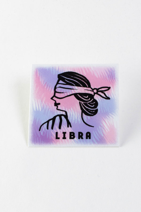 A square sticker with a purple, pink, and light blue background. A black outline of a blindfolded woman and black text that reads "Libra" are in the center.