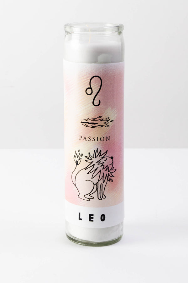 A tall glass votive candle with a white, yellow, and pink label with symbols depicting the astrological sign of Leo. The black text on the bottom reads "Leo."