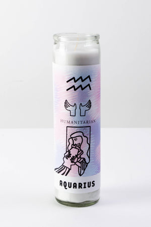 A tall white glass votive candle with a pale pink and blue sticker depicting the symbols of the astrological sign Aquarius.