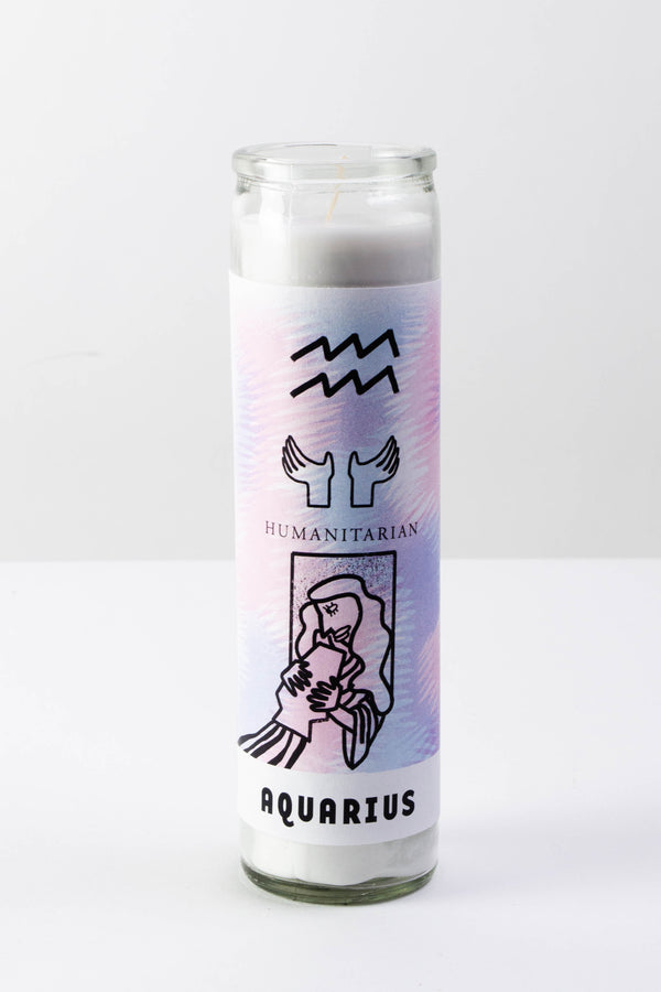A tall white glass votive candle with a pale pink and blue sticker depicting the symbols of the astrological sign Aquarius.