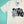 Load image into Gallery viewer, An off-white color t-shirt with black ink featuring illustrations of the Bride of Frankenstein, Lily Munster, Elvira, and Morticia Addams and the words &quot;Ghoul Gang&quot; sits on top of a flat teal and white background.
