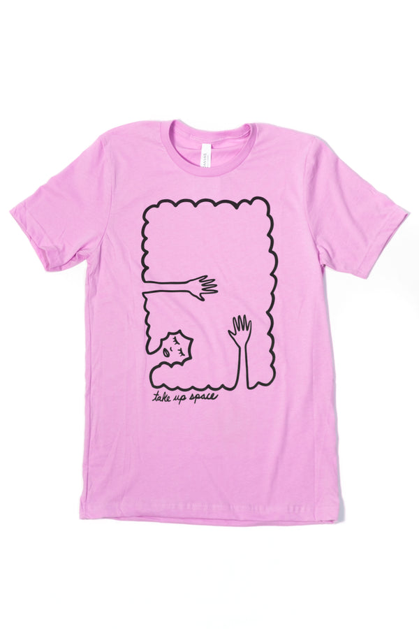 Lilac tshirt on a white background. The Tshirt design is black line work of a person laying down with their hands abover their head laying on their hair. The hair creates a rectangle border. Under the illustration the shirt says Take Up Space.