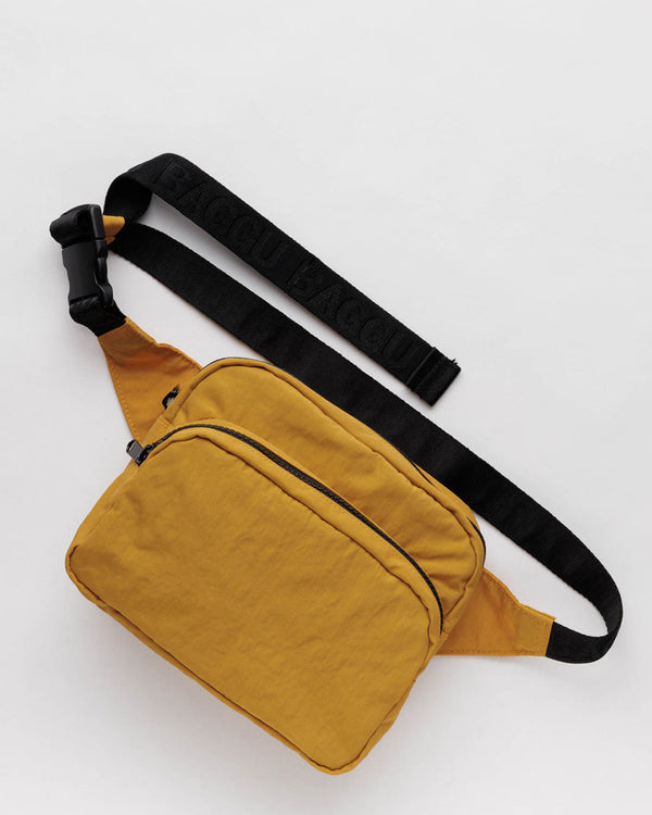 Yellow Turmeric two pocket fanny pack with black straps laid out on a white background. The straps are black with black text that says Baggu in a repeating pattern.