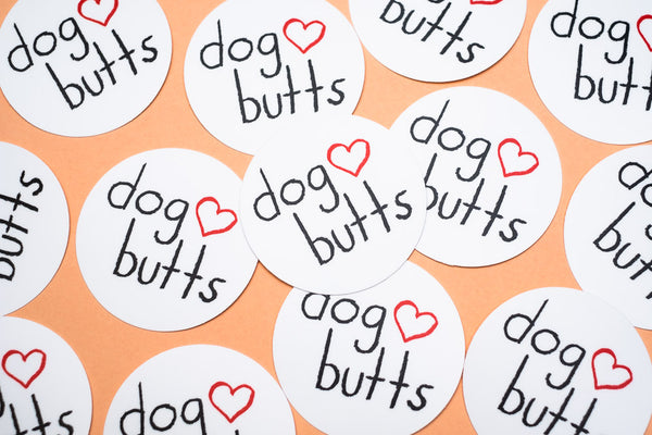 An orange background with many "dog butts" stickers arranged in the foreground. 