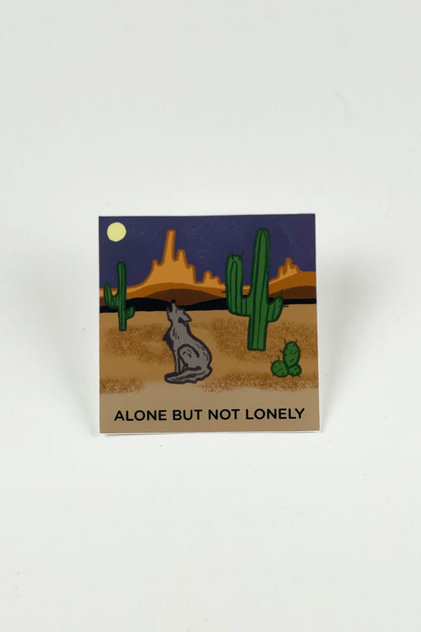 A square sticker showing an illustrated wolf howling in the desert at night. Text at the bottom reads "Alone but not lonely."