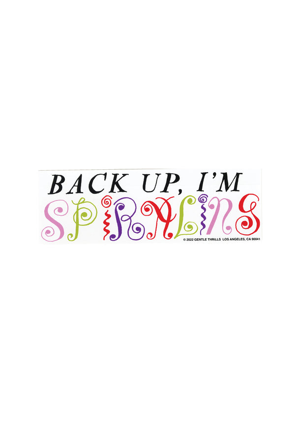 A white bumper sticker with the words "Back up, I'm Spiraling."