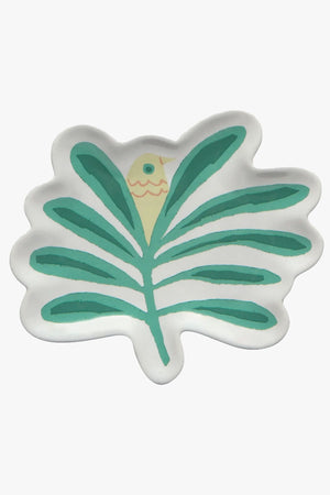 An off-white ceramic dish with green foliage and a small yellow bird peeking out between the leaves.