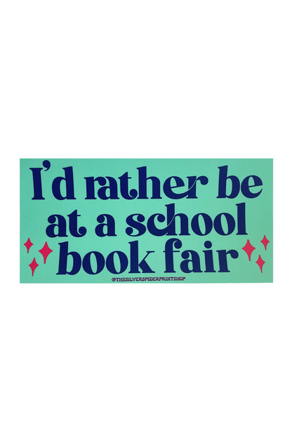 A teal rectangular bumper sticker with navy text that reads "I'd rather be at a school book fair." 