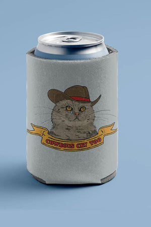 A gray can koozie with an illustration of a cowboy hat-wearing cat crying a single tear sits on a light blue background. The text under the cat reads "cowboys cry too" in red text on a yellow banner.