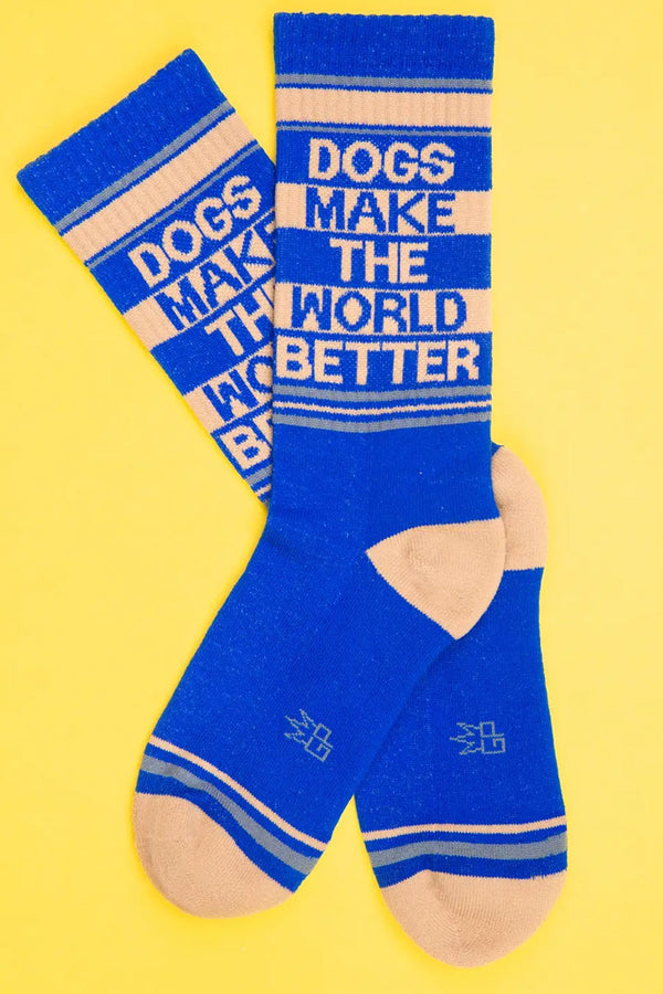 Tall mid calf crew socks. The socks are blue with tan stripes across the top and tan heels and toes. The socks say Dogs Make The World Better in alternating colors of Tan and Blue. Yellow background.