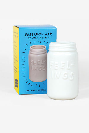 White Ceramic vase shaped like a mason jar. The jar says Feelings on the front. Pictured next to the jar is the yellow and blue box it comes in. White background.