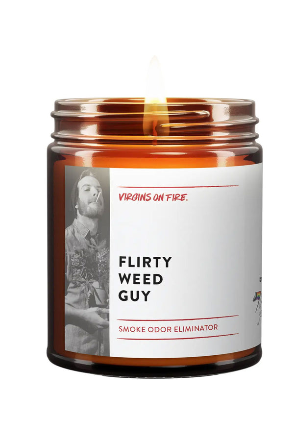 Amber glass candle jar. The white label says Flirty Weed Guy and features a black and white photo of a man smoking a rolled cigarette. White background.