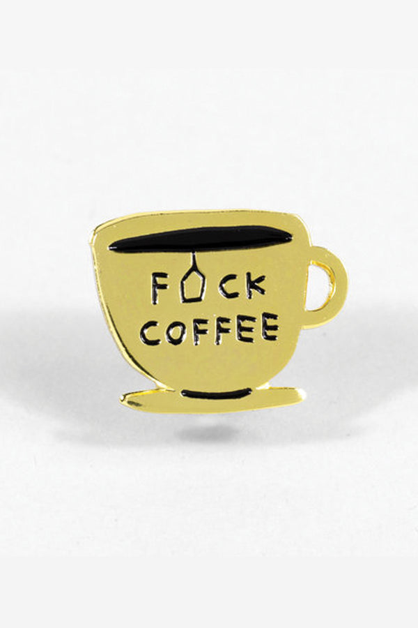 A gold die-cut enamel pin in the shape of a mug and saucer. The text reads "Fuck Coffee" with the "U" replaced by the outline of a tea bag. 