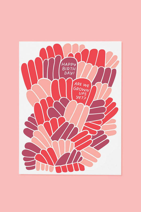 A white greeting card with illustrated blobs of purple, salmon, and red. The text reads "Happy Birthday! Are we grown ups yet?"