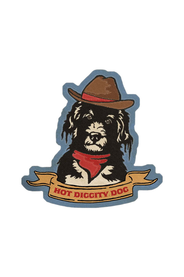 A die cut sticker of a black and white dog wearing a cowboy hat and red bandana. The background of the sticker is dusty blue and reads "hot diggity dog" in red text at the bottom.