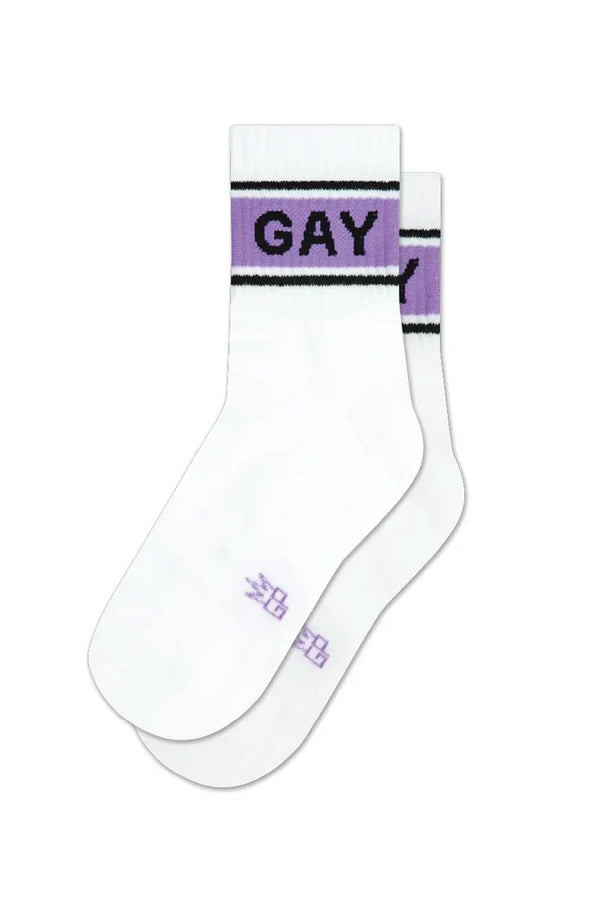White ankle crew socks. The socks have two black stripes at the top with a thicker purple stripe in-between them. On the purple strip in black lettering the socks say GAY. White background.