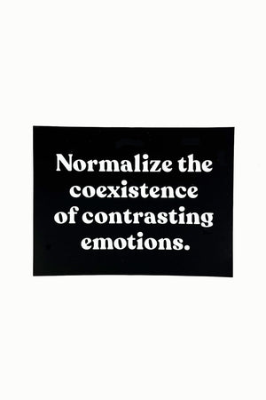 A black rectangular sticker with white text that reads "Normalize the coexistence of contrasting emotions."